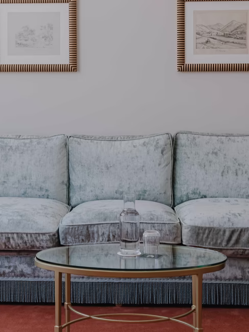 Sitzecke mit himmelblauer Couch und einem Glastisch
