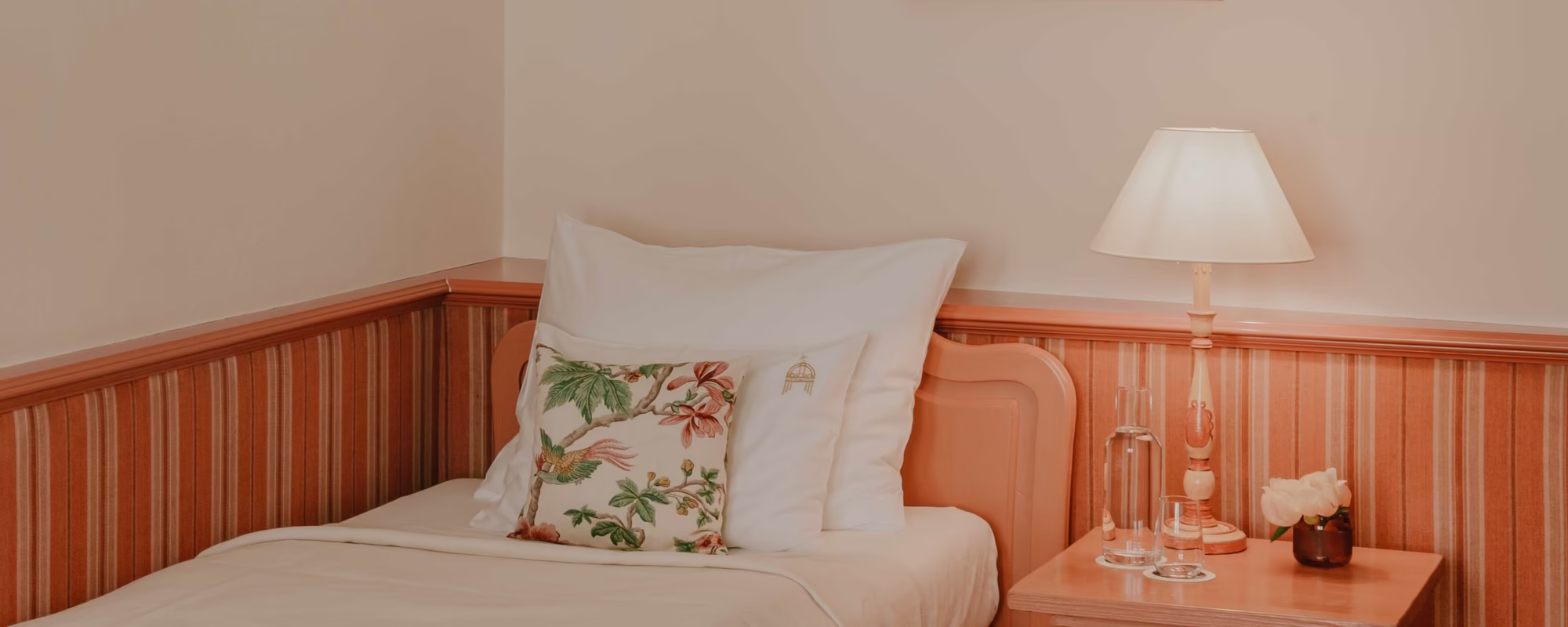 Einzelbett mit kleinem Nachttisch und und Lampe