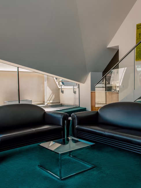 Die zweiteilige Couch mit einem eleganten Glastisch.
