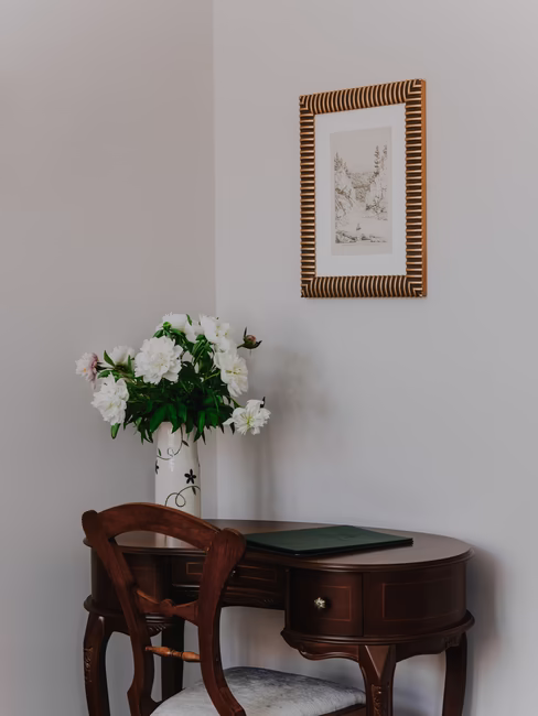 Schreibtisch mit Stuhl im alten Design mit Deko Vase mit weißen Pfingstrosen